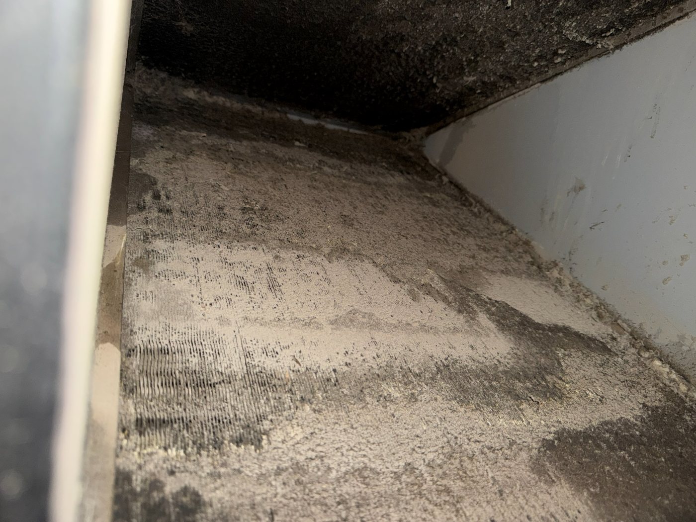 Heavy mat of debris covering HVAC coil fins inside the cabinet