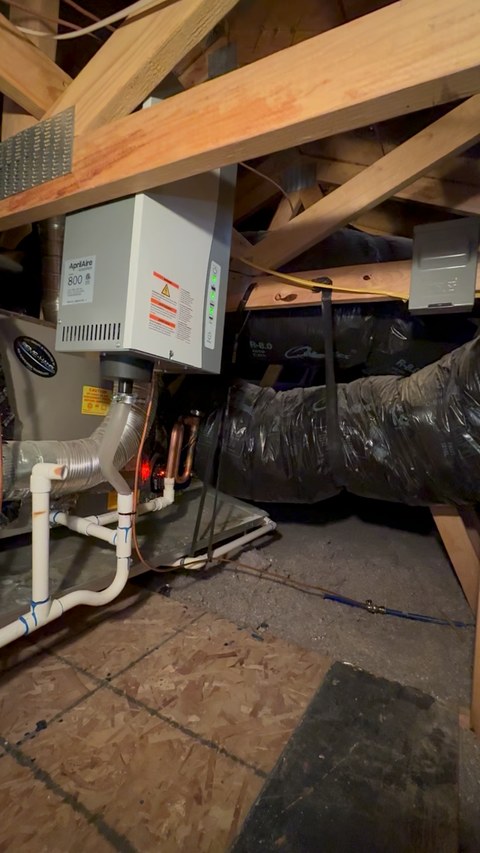 Installed Aprilaire Model 800 cabinet with steam hose and condensate piping in an attic